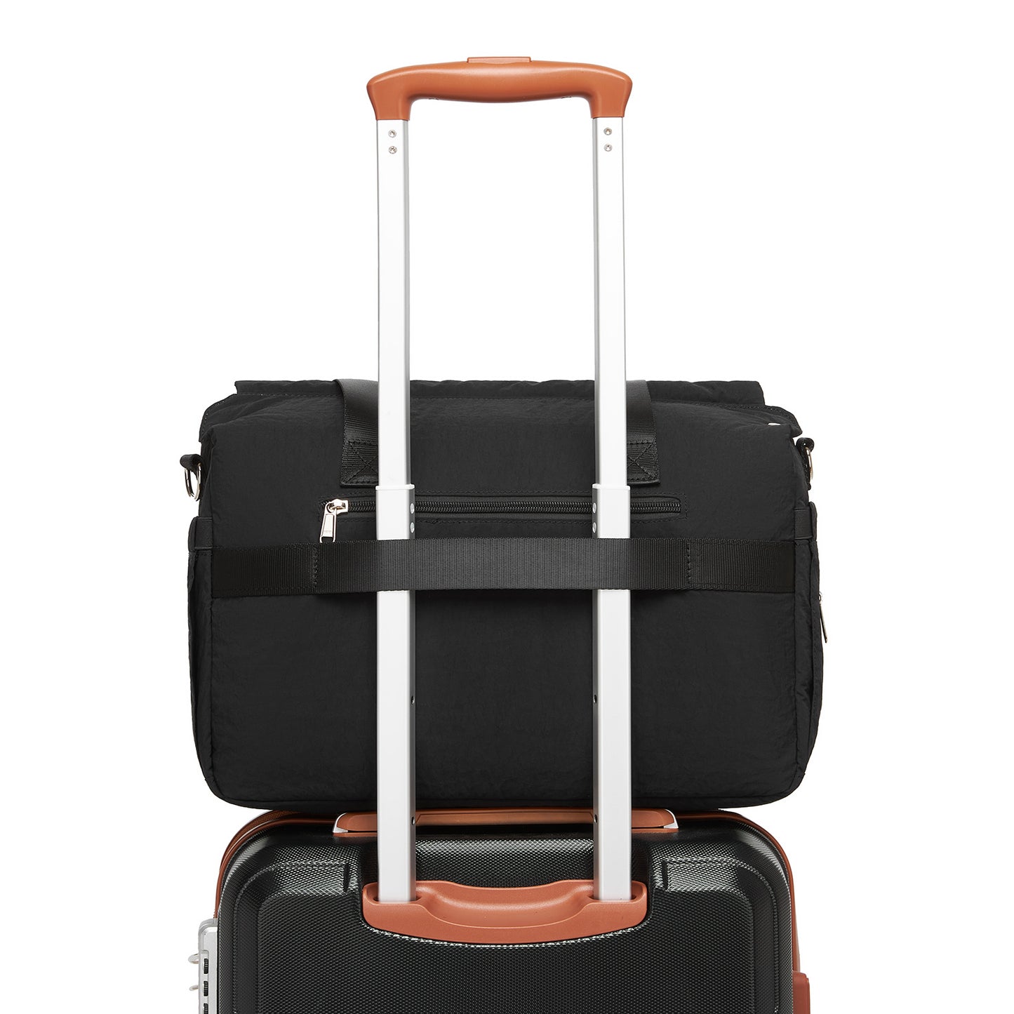 Black quilted diaper bag attached to rolling suitcase handle for travel compatibility
