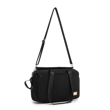 Rear view of black structured duffel diaper bag with adjustable trolley strap and silver hardware
