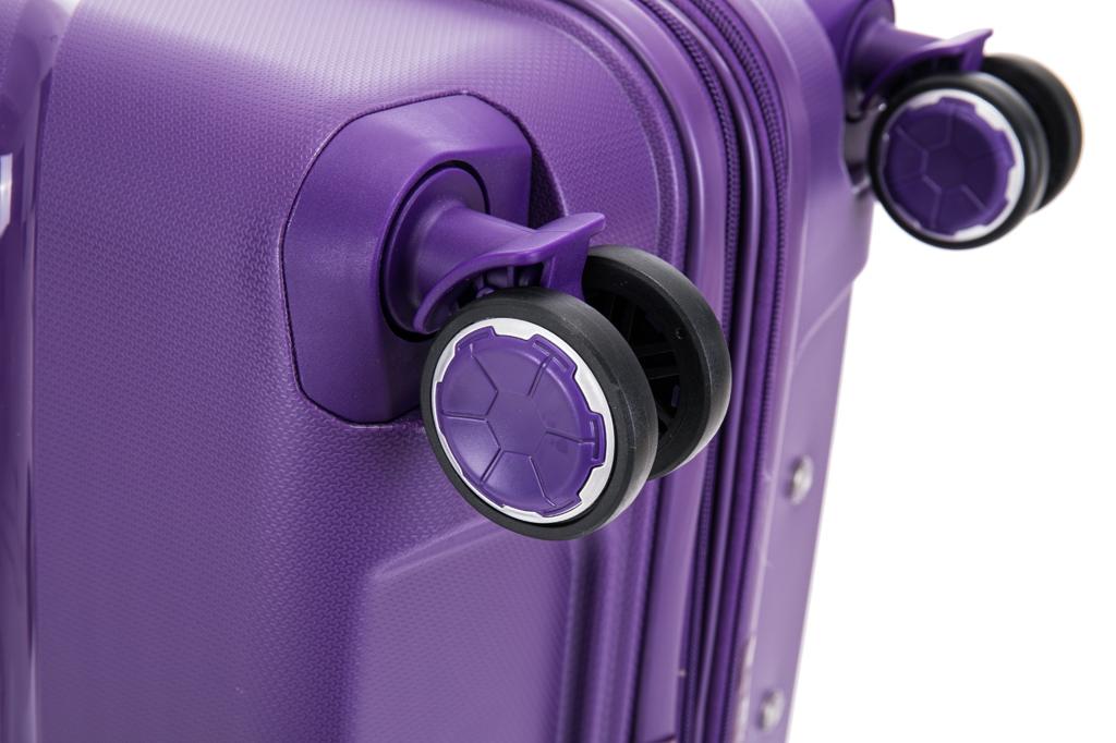Detail view of dual wheel spinner caster assembly on purple hard shell luggage with hexagonal hub caps