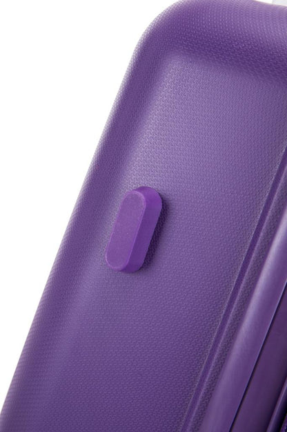 Close up of purple suitcase corner showing diamond textured polypropylene shell and flush push button latch