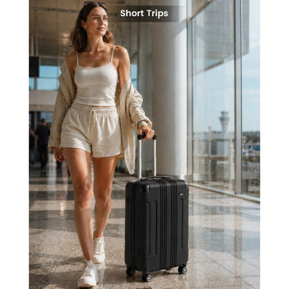 Woman pulling black 19-inch carry-on through airport terminal with extended handle and spinner wheels