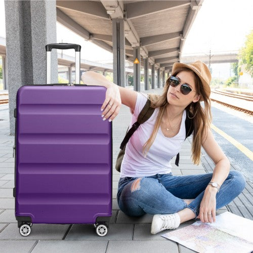 Woman leaning on purple 24-inch spinner suitcase at train station platform with map