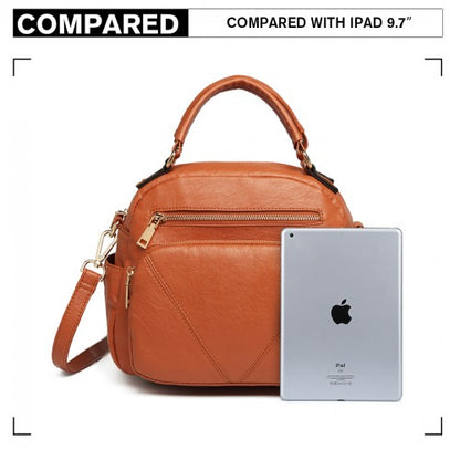 Compact brown bowler handbag next to iPad for scale, featuring front zip pocket and rounded shape